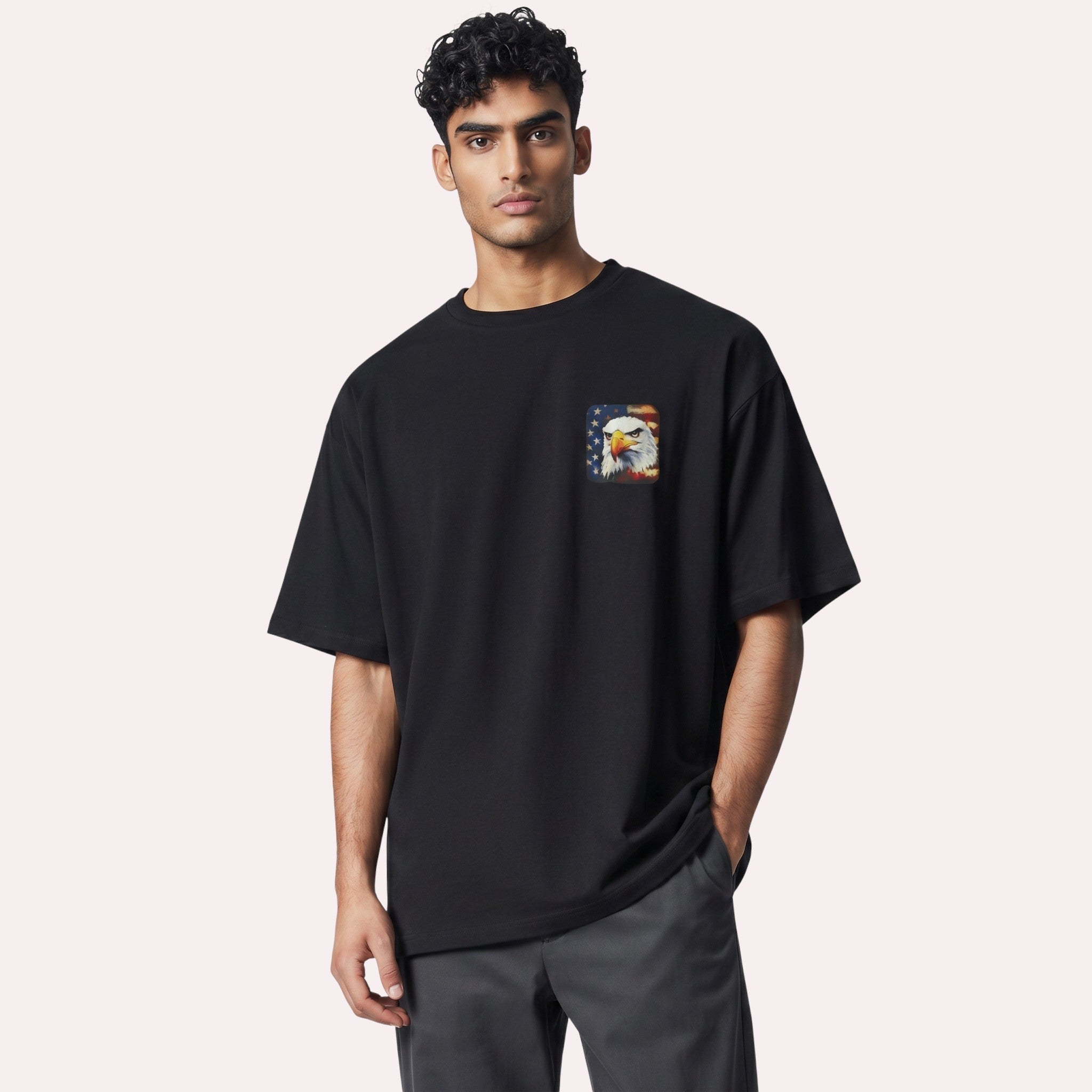 TrendyShift.Com black cotton graphic tee featuring a small bald eagle and American flag chest print on a male model