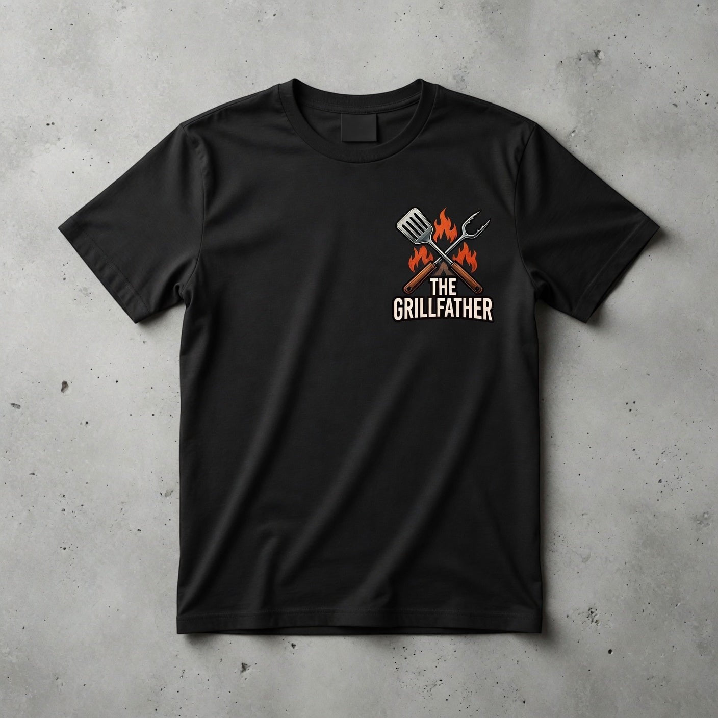 TrendyShift.Com black cotton crew neck t-shirt featuring The Grillfather graphic with a spatula and tongs on the chest.