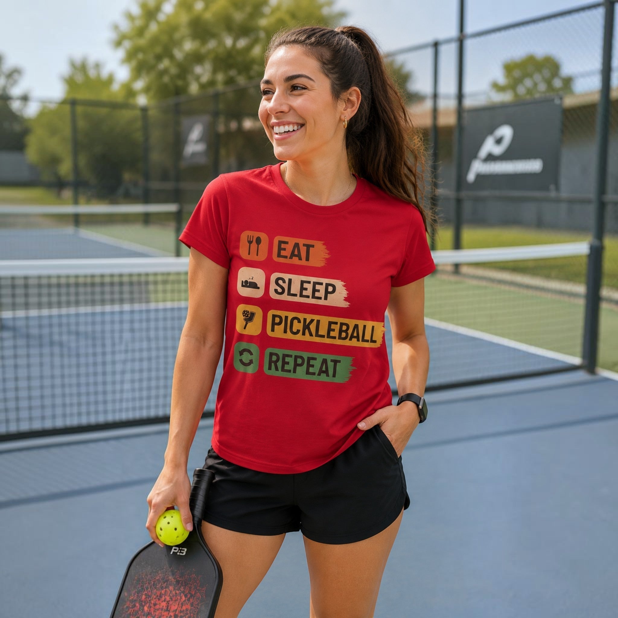 TrendyShift.Com red cotton pickleball t-shirt with Eat Sleep Pickleball Repeat graphic worn by a smiling woman