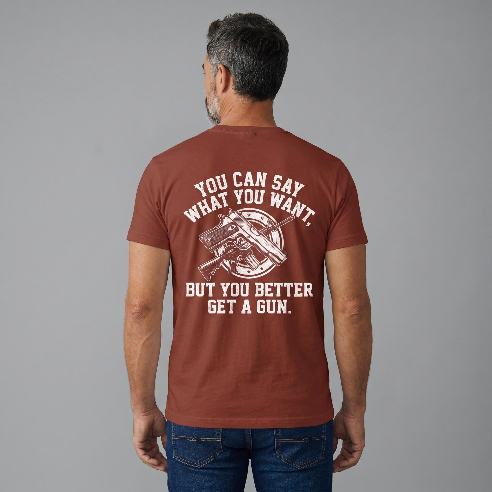 TrendyShift.Com rust-colored cotton t-shirt with white graphic print featuring a gun and bold text on the back