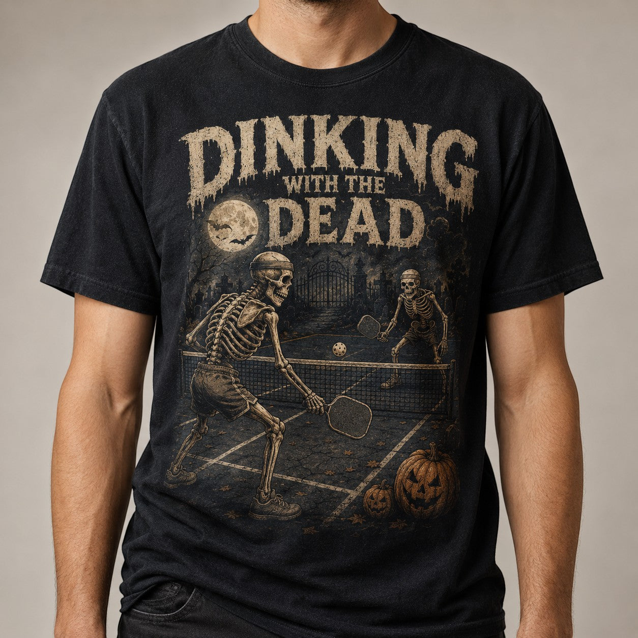 WearTheJoke.com black t-shirt featuring skeletons playing pickleball with distressed vintage Halloween graphics.
